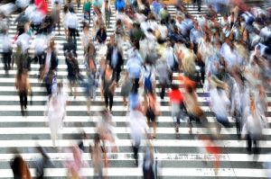 Multitud de gente cruzando un paso de zebra en una imagen movida para dar la sensación de dinamismo.