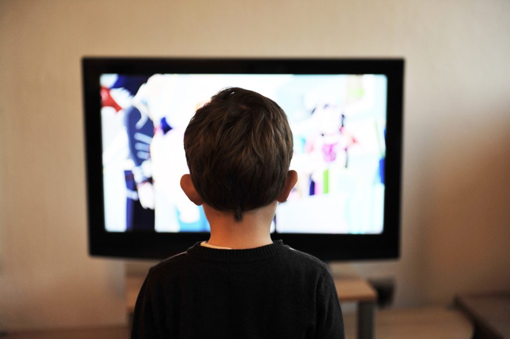 Niño de espaldas mirando la televisión.
